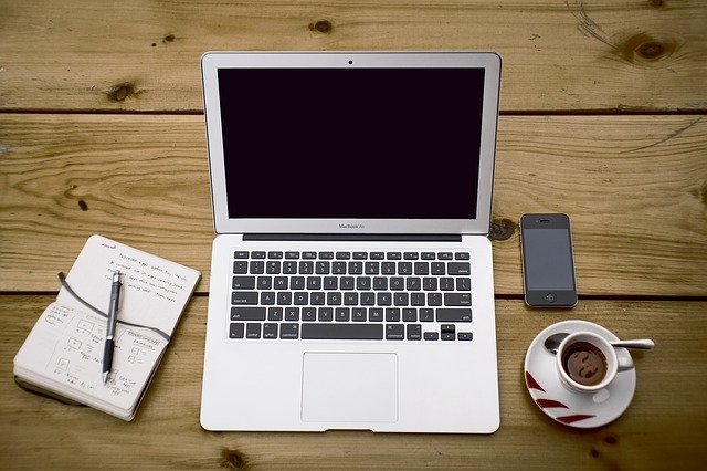 Photo of journal, laptop, phone and cup of coffee